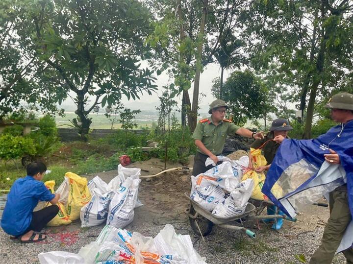 Công an các xã của tỉnh Bắc Ninh giúp dân chuẩn bị bao tải cát chèn mái nhà. Ảnh: Nguyễn Anh