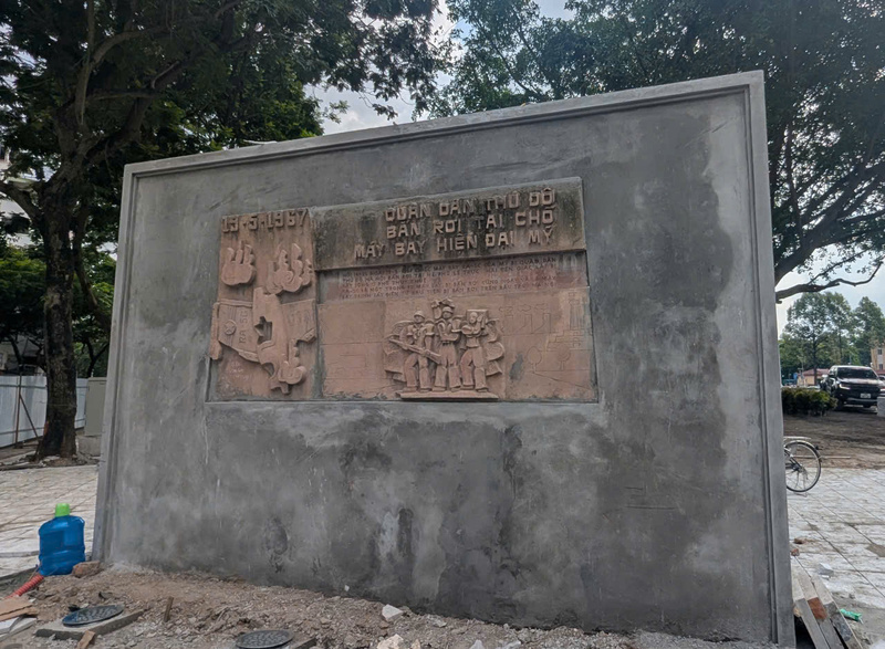 Bức phù điêu ghi lại chiến công bắn rơi máy bay Mỹ ngày 19/5/1967 trên phố Lê Trực được gia cố vững chắc tại vị trí dựng ban đầu trên một đoạn tường rào của công trình cũ. Ảnh: QL