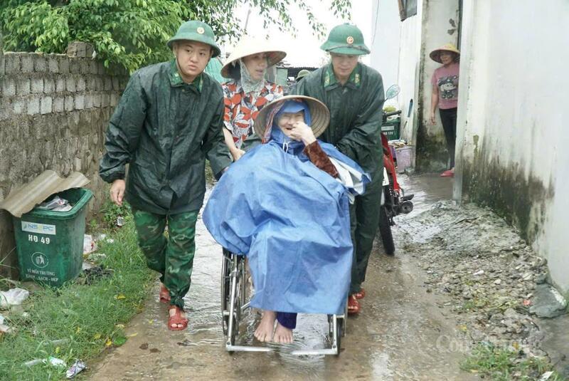 Một cụ già do sức khỏe yếu, được lực lượng chức năng cùng người thân hỗ trợ đến điểm tránh trú