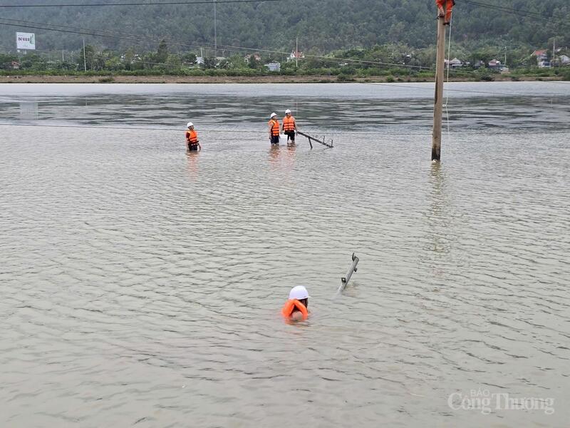 Công nhân Công ty Điện lực Thanh Hóa bơi trong dòng nước để vận chuyển thiết bị sửa chữa khắc phục sự cố lưới điện tại khu vực Nghi Sơn