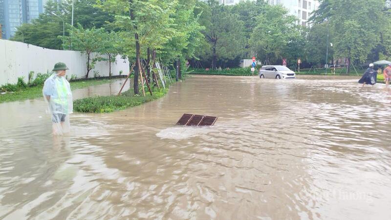 Lực lượng ứng trực được tăng cường tại các điểm úng ngập để mở nắp hố ga, thu dọn rác chắn miệng cống, hỗ trợ thoát nước nhanh. Ảnh: Hải Sơn