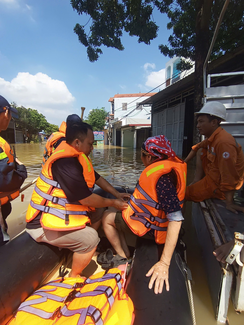 Cảnh sát cấp phát áo phao cứu nạn cứu hộ cho người dân để đảm bảo an toàn. Ảnh: Công an TP. Hà Nội