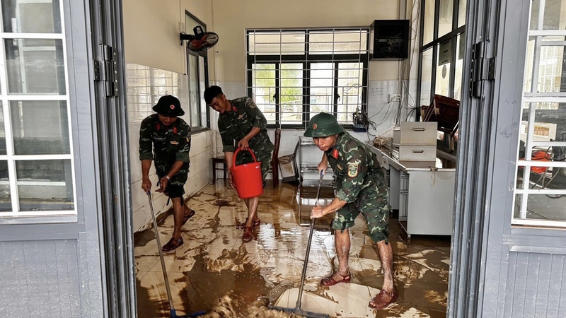 Lực lượng vũ trang phối hợp với người dân địa phương dọn dẹp bùn đất sau mưa lũ.