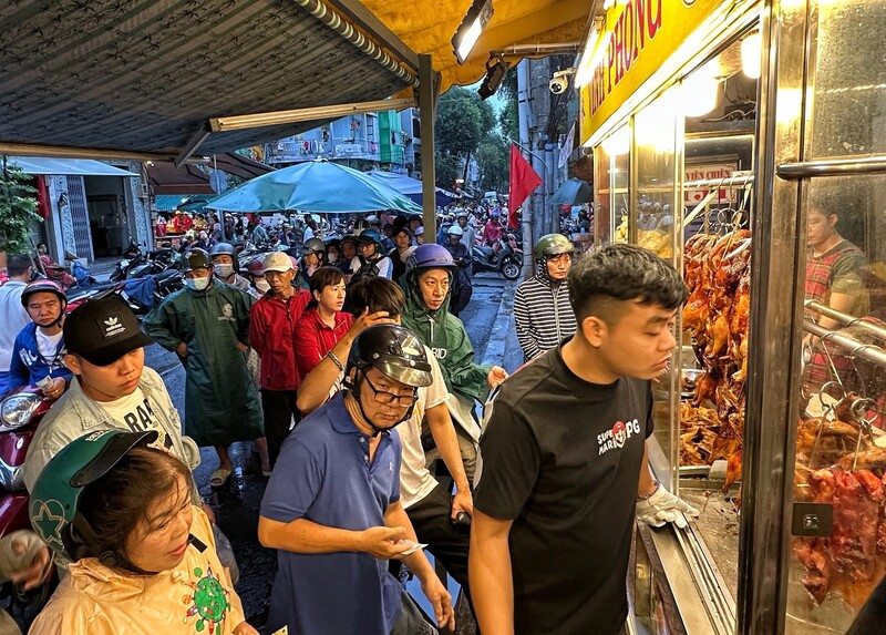 Người dân xếp hàng mua vịt quay, heo quay cho ngày vía Thần Tài hôm nay. Ảnh: Cao An Biên